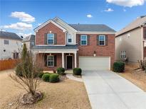 Charming two-story brick home with a manicured front yard and attached two-car garage at 28 Dover Commons Dr, Tucker, GA 30084