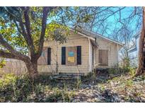 Distressed home with boarded up windows and overgrown landscaping needing full rehabilitation at 1314 North Avenue, Atlanta, GA 30318