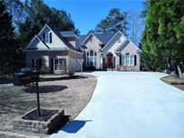 Charming brick home featuring a well-manicured lawn, long driveway, and inviting red front door at 2513 Galloways Farm Drive Nw, Acworth, GA 30101