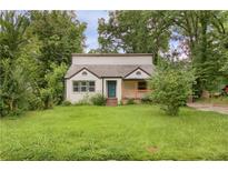 Charming home with a front yard, featuring a covered porch and mature trees at 444 Sargent Se Dr, Atlanta, GA 30315