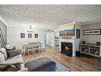 Cozy living room with a fireplace, dining area, and comfortable seating arrangement at 1605 Beaumont Cir, Duluth, GA 30096