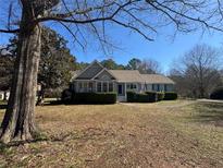 Charming single-story home with a manicured front lawn and trimmed hedges on a sunny day at 3030 Scott Rd, Marietta, GA 30066