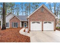 Charming single-Gathering home with a brick facade, two-car garage, and manicured lawn at 3242 Country Walk Drive, Powder Springs, GA 30127