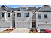 Charming townhouse featuring a two-car garage, white brick, and classic architectural details at 1277 Fern Ridge Ct # 22, Norcross, GA 30093