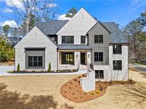 Stunning two-story home featuring light brick, dark window frames, and a landscaped front yard at 88 Lakeshore Ne Cir, Marietta, GA 30067
