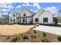 Stunning two-story white home featuring modern design elements and a well-manicured lawn with tasteful landscaping at 4100 Thunderbird Dr, Marietta, GA 30067