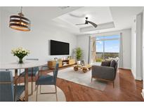 Bright living room featuring a dining area, hardwood floors, and balcony access with great natural light at 325 E Paces Ferry Ne Rd # 907, Atlanta, GA 30305