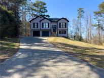 Charming two-story home with a long driveway and attached two car garage at 1305 Country Acres Ln, Lawrenceville, GA 30045