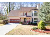 Charming two-story home featuring a well-manicured lawn, attached two car garage and inviting front porch at 3175 Pond Ridge Trl, Snellville, GA 30078