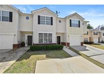 Charming townhome featuring a well-manicured lawn, a covered entrance, and a one-car garage at 7316 Wagon Wheel Ct, Jonesboro, GA 30236