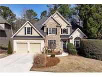 Charming two-story home featuring stone accents, a manicured lawn, and a two-car garage at 994 Fairview Club Cir, Dacula, GA 30019