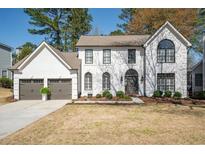 Charming two-story home featuring a manicured lawn and a two-car garage with appealing architectural design at 11745 Windbrooke Way, Johns Creek, GA 30005