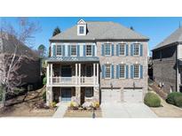 Stunning two-story brick home showcasing a covered porch, two-car garage, and well-manicured landscaping at 6300 Mount Vernon Oaks, Sandy Springs, GA 30328