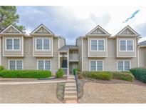 Inviting condo with neutral siding, well-maintained landscaping, and staircase leading to upper-level units at 14 Muncy Se Ct, Smyrna, GA 30080