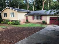 Charming single-story home featuring a brick facade, red shutters, and an attached garage at 3034 Kent Ct, Duluth, GA 30096