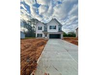 Charming two-story home with gray accents, an open garage, and a neatly paved driveway at 1462 Stephens View Dr, Loganville, GA 30052