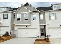 Charming townhome featuring a two-car garage, brick accents, and elegant modern design at 1287 Fern Ridge Ct # 23, Norcross, GA 30093