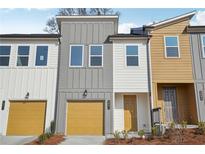 Charming townhome with a vibrant yellow garage door and complementary exterior paint colors at 1694 Gunnin Nw Trce # 245, Atlanta, GA 30318