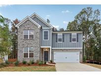Charming two-story home with a brick and gray facade and a two-car garage, exuding curb appeal at 5384 Heron Bay Blvd, Locust Grove, GA 30248
