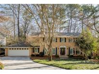 Charming two-story brick home with manicured lawn, attached garage and mature trees at 5385 Saffron Dr, Dunwoody, GA 30338