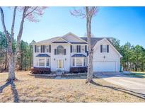 Traditional two-story home boasting a two-car garage and well-manicured landscaping at 6219 Wurtenburg Ct, Stone Mountain, GA 30087
