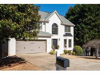 Charming two-story home with a well-manicured lawn, attached garage, and lovely curb appeal at 7880 Brands Hatch Blvd, Cumming, GA 30040