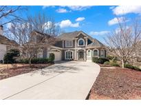 Stately two-story home with a long driveway, manicured landscaping, and a three-car garage at 160 Antler Trl, Alpharetta, GA 30005