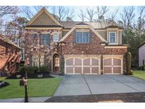 Beautiful two story brick and stone home with a three car garage and well manicured lawn at 3330 Camellia Ln, Suwanee, GA 30024