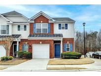 Charming brick townhome with blue shutters, a garage, and a well-maintained lawn at 83 Brookway Trce, Norcross, GA 30071