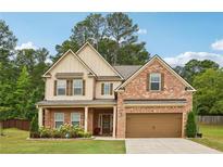 Charming two-story brick home with a well-manicured lawn and attached two-car garage at 244 Lotus Cir, Mcdonough, GA 30252
