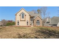 Two-story home with a blend of stucco and stone, arched windows, and a well-manicured lawn at 607 Delphinium Nw Blvd, Acworth, GA 30102