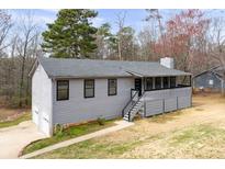 Charming single-story home with gray siding, black trim, a front porch, and an attached two-car garage at 2995 Clearwater Dr, Douglasville, GA 30135