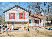 Charming split-level home featuring stone accents, red shutters, and a cozy front porch at 1040 Forest East Dr, Stone Mountain, GA 30088