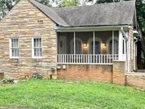 Charming stone cottage featuring a screened porch and well-maintained yard at 1247 Monroe Ne Dr, Atlanta, GA 30306