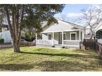 Charming home with a welcoming front porch and a well-maintained lawn surrounded by a picket fence at 1084 Kirkwood Se Ave, Atlanta, GA 30316