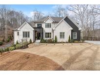 Attractive two-story home with a well-manicured lawn and three-car garage at 120 Nezhat Pl, Atlanta, GA 30350