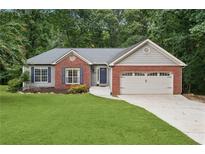 Charming single-Gathering home with brick accents, two-car garage, and a well-manicured lawn and mature trees at 4125 Gables Pl, Buford, GA 30519