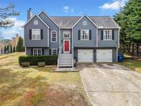 Charming two-story home with gray siding, red front door, and a two-car garage at 113 Emerald Pines Dr, Dallas, GA 30157