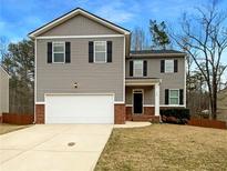 Charming two-story home with gray siding, black shutters, and a two-car garage, offering classic curb appeal at 145 Ella Dr, Covington, GA 30016