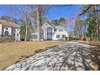 Inviting two-story home with a white exterior, black shutters and a long concrete driveway at 1303 Angel Falls Sw Ln, Atlanta, GA 30311