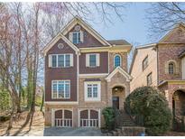 Charming exterior of a brown two-story home with a two-car garage and landscaped front yard at 2647 Brickell Sq, Atlanta, GA 30341