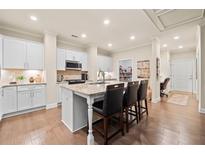 Bright kitchen features white cabinets, granite countertops, and a central island with bar seating at , Acworth, GA 30101
