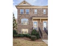 Charming townhome featuring a classic brick facade and well-manicured landscaping at 3032 Hartford Mill Pl, Duluth, GA 30097