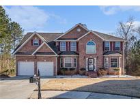 Charming two-story brick home featuring a two-car garage and professionally landscaped front yard at 4230 Spur Look Xing, Douglasville, GA 30135