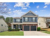 Charming two-story home featuring a well-manicured lawn, attached two car garage, and a traditional brick and siding facade at 1840 Beyers Landing Dr, Buford, GA 30519