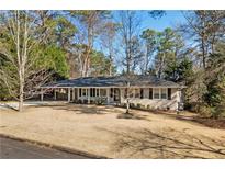 Charming single-story home featuring a cozy covered porch and a well-maintained lawn, surrounded by lush trees at 2723 Esquire Way, Tucker, GA 30084