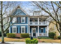 Charming two-story home with blue siding, double porches, and landscaped front yard at 1514 Gilstrap Nw Ln, Atlanta, GA 30318