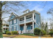 Charming two-story home featuring a double porch, blue siding, and manicured landscaping at 1514 Gilstrap Nw Ln, Atlanta, GA 30318