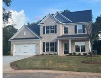 Charming two-story brick home featuring black shutters, white trim, and a manicured front lawn at 5310 Julep Ct, Cumming, GA 30028