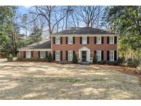 Beautiful two-story brick home with a manicured lawn and traditional architectural details at 2947 Margaret Mitchell Nw Ct, Atlanta, GA 30327